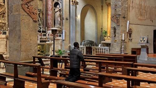 Immagine con chiesa, banchi, uomo, panche, preghiera, ceri, interno, pregare, devozione, statua