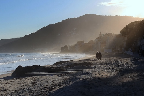 Immagine con mare, spiaggia, sabbia, onde, persone, montagne, cielo