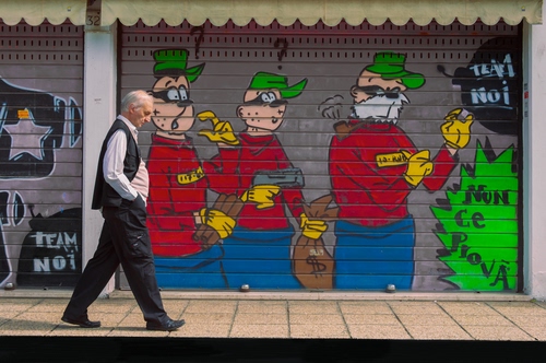 Immagine con bassotti, serranda, passante, uomo, saracinesca, fumetto, murales, banda, rosso, ladri, dipinto, persona