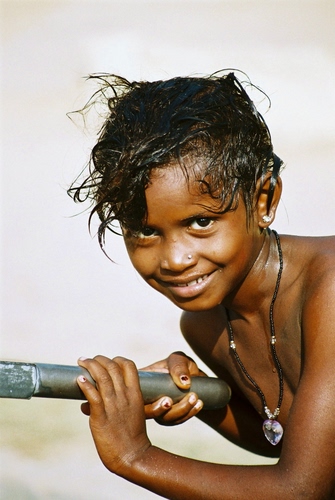 Immagine con collana, occhi, capelli, sorriso, mani, bambino, bocca, bambina, ciondolo, naso, sguardo, neri, ritratto