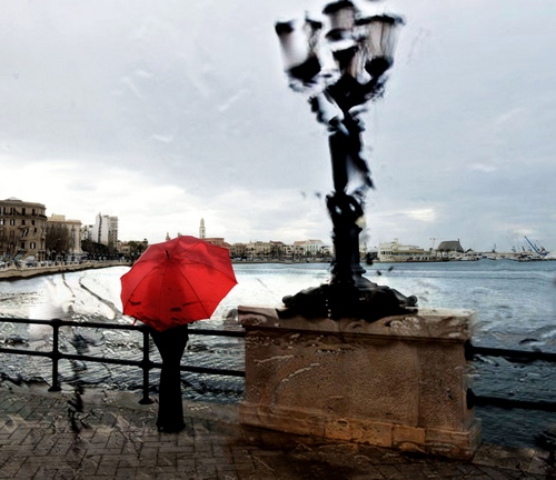 Immagine con lampione, ombrello, rosso, pioggia, mare, ringhiera, acqua