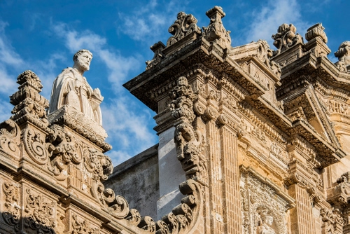 Immagine con chiesa, barocco, cielo, nuvole, statua, decorazioni, facciata, bassorilievi, statue, azzurro, dettaglio, sculture, scultura
