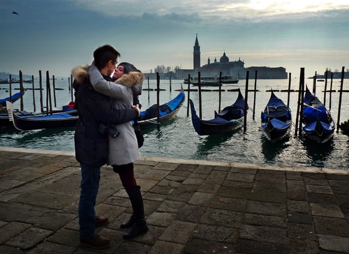 Immagine con gondole, venezia, campanile, mare, laguna, coppia, abbraccio, pali, blu, donna, uomo, fidanzati, chiesa, acqua, ragazzi, cielo, amore, innamorati, barche, due, bacio