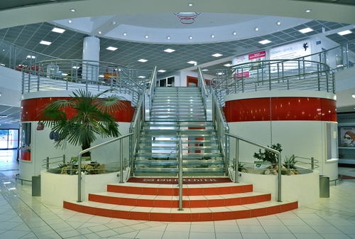 Immagine con scala, luci, palma, piante, rosso, gradini, scalinata, atrio, colonne, scalini, ringhiera, negozio, scale, interno, corrimano