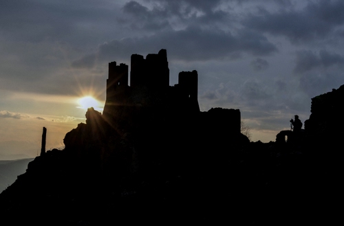 Immagine con castello, sole, tramonto, nuvole, controluce, torri, cielo, rudere, raggi, silhouette, nero, rocca, persona, rovine