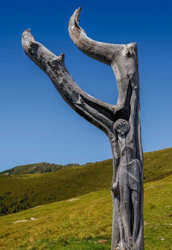 Immagine con scultura, legno, tronco, cielo, verde, crocifisso, azzurro, montagna, prato, albero, cristo, gesù, secco, erba, incisione