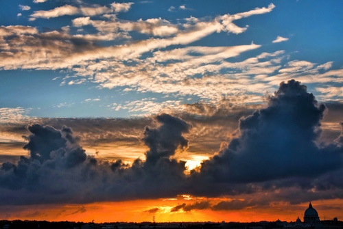 Immagine con nuvole, tramonto, cielo, sole, cupola, arancione, giallo, rosso, silhouette, azzurro, alba, controluce, cirri