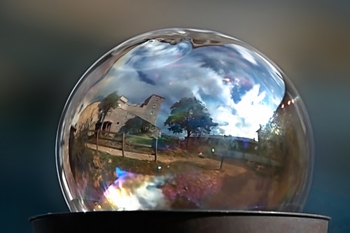 Immagine con sfera, nuvole, cielo, riflesso, staccionata, albero, alberi, casa, vetro, riflessi, palla, castello, azzurro, paesaggio