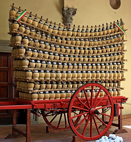 Immagine con fiaschi, carretto, rosso, ruote, vino, ruota, porta, tanti, paglia, capitello, legno, carro, esposizione, vetro, bandiera, mostra, corda, bottiglie, tricolore