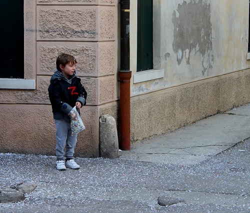 Immagine con coriandoli, carnevale, bambino, angolo, strada, bimbo, marciapiede, grondaia, sacchetto