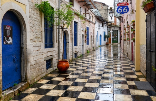 Immagine con porte, vicolo, insegna, vaso, piante, verde, piastrelle, azzurro, blu, bagnato, pianta, scacchi, finestre, lampioni, quadrati, vasi, numero, nero, fiori, bianco, sessantasei, strada, porta, archi, insegne, portoni, inferriate, tettoie