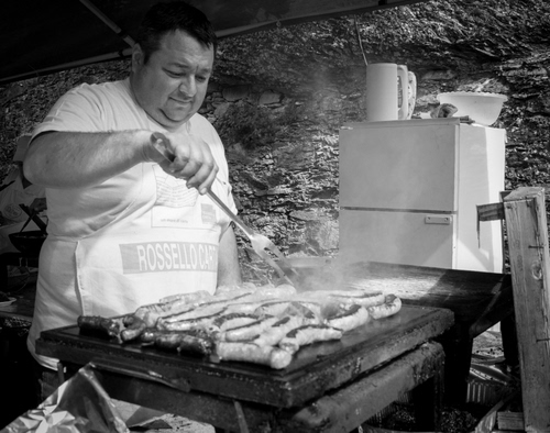 Immagine con cuoco, griglia, bianconero, forchettone, salsicce, cibo, fumo, brace, grigliata, carne